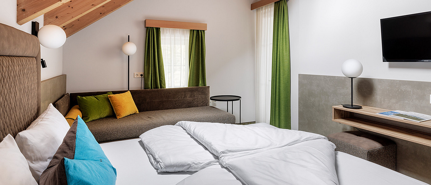 Room with large double bed, sofa bed and TV.