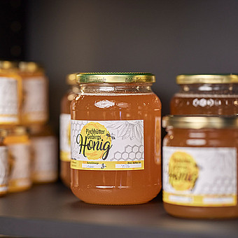 Different types of honey on one shelf.