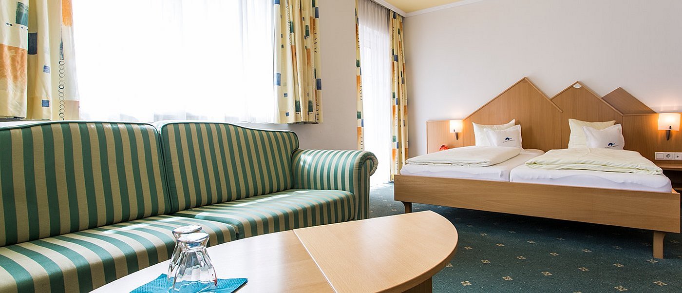 Hotelzimmer mit grüner Couch.