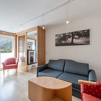 A black sofa in a hotel room with a balcony.