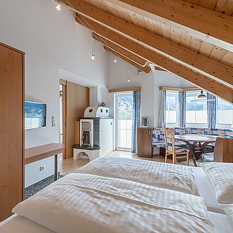 Room with double bed, fireplace and dining area.