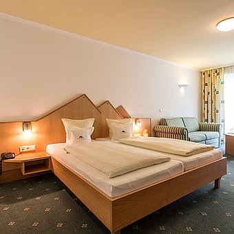 Ein großes Doppelbett in einem Hotelzimmer.