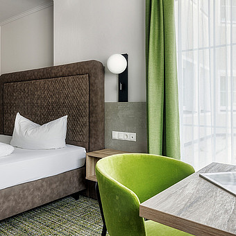 Blick auf ein großes Bett in einem Zimmer.