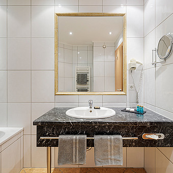 Ein Waschbecken mit einem großen Spiegel.