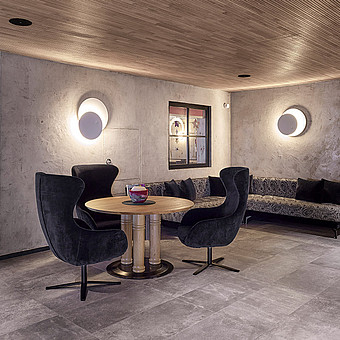 Ein runder Tisch mit violetten Samtsesseln.