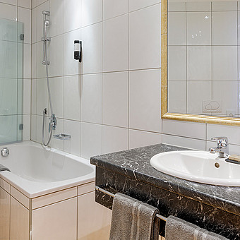 Eine Badewanne und ein Waschbecken in einem Apartment.