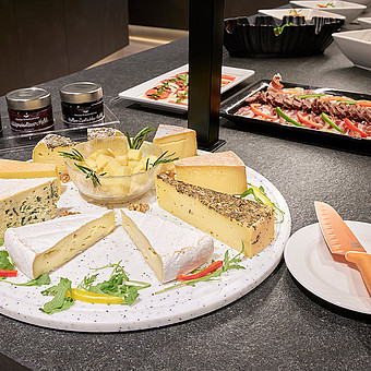 There are various types of cheese on a plate.