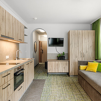 Eine Küche steht vor einer kleinen Couch.