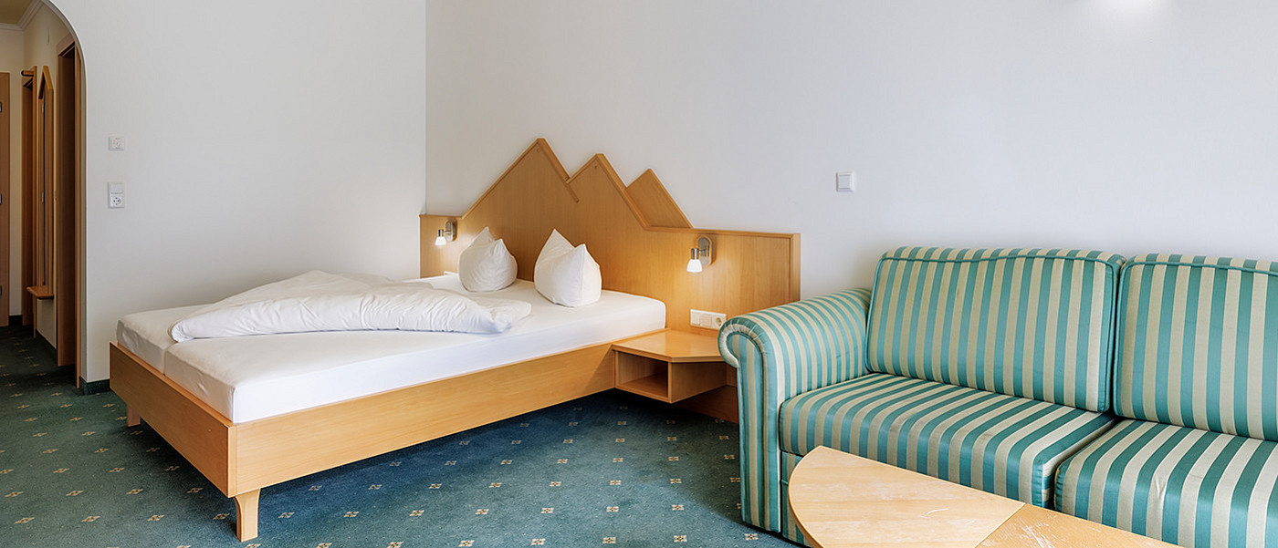 Couch next to a double bed.