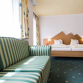 Hotelzimmer mit Sofa und Bett.