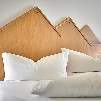 Großes Doppelbett in einem Zimmer.