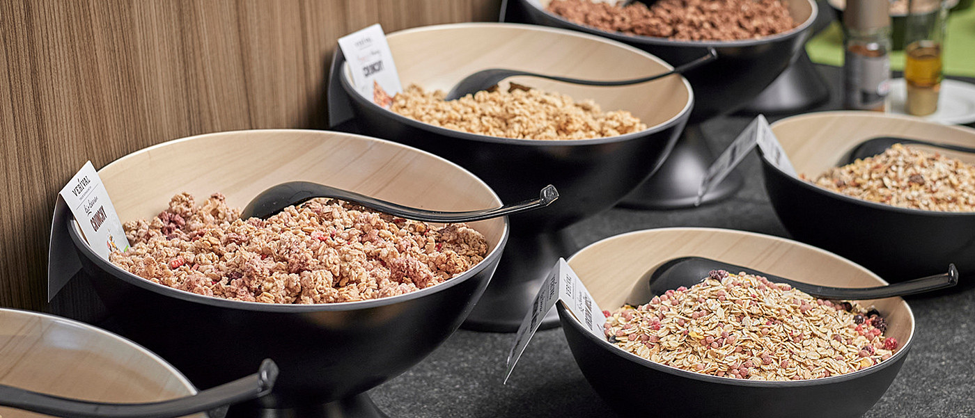 Bei einem Frühstsücksbuffet stehen Schüsseln mit verschiedenen Müslisorten.