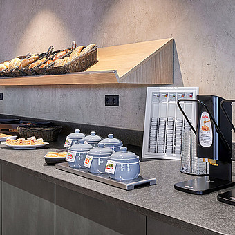 Ein Frühstücksbuffet mit verschiedenen Brotsorten, Kuchen und Aufstriche.