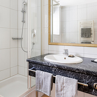 A bathroom with washbasin and shower.