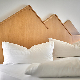 Pillows and a blanket on a bed.