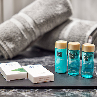 Shampoo and body lotion, soaps and towels in one bathroom.