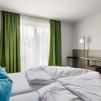 A small television hangs in front of a double bed.