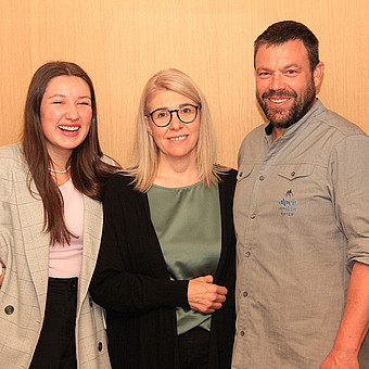 Ein Mann und zwei Frauen posieren für ein Foto.