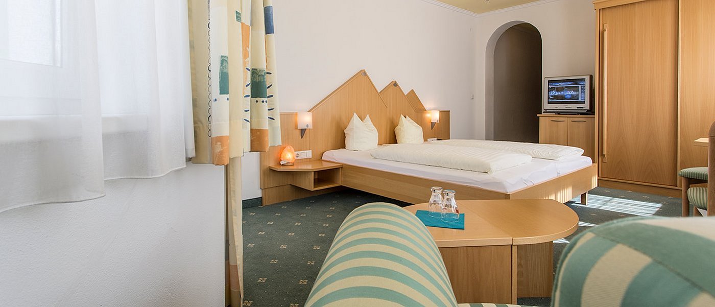 Gemütliches Hotelzimmer mit Doppelbett.