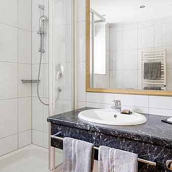 Eine Dusche und ein Waschbecken in einem Badezimmer.